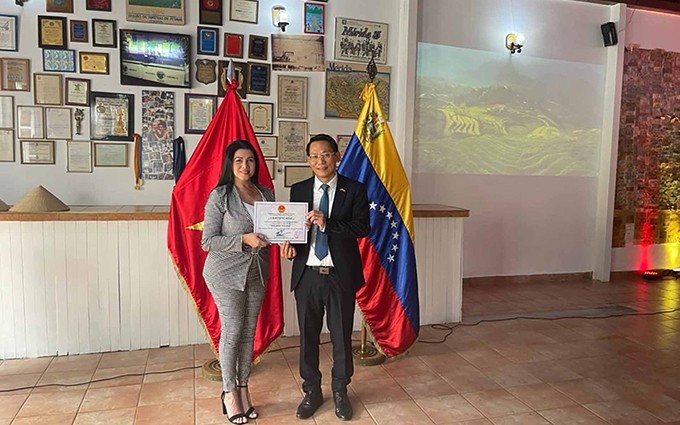 El embajador Le Viet Duyen entrega el Certificado a la propietaria de la heladería, Isbellis Da Silva. (Fotografía: VNA)